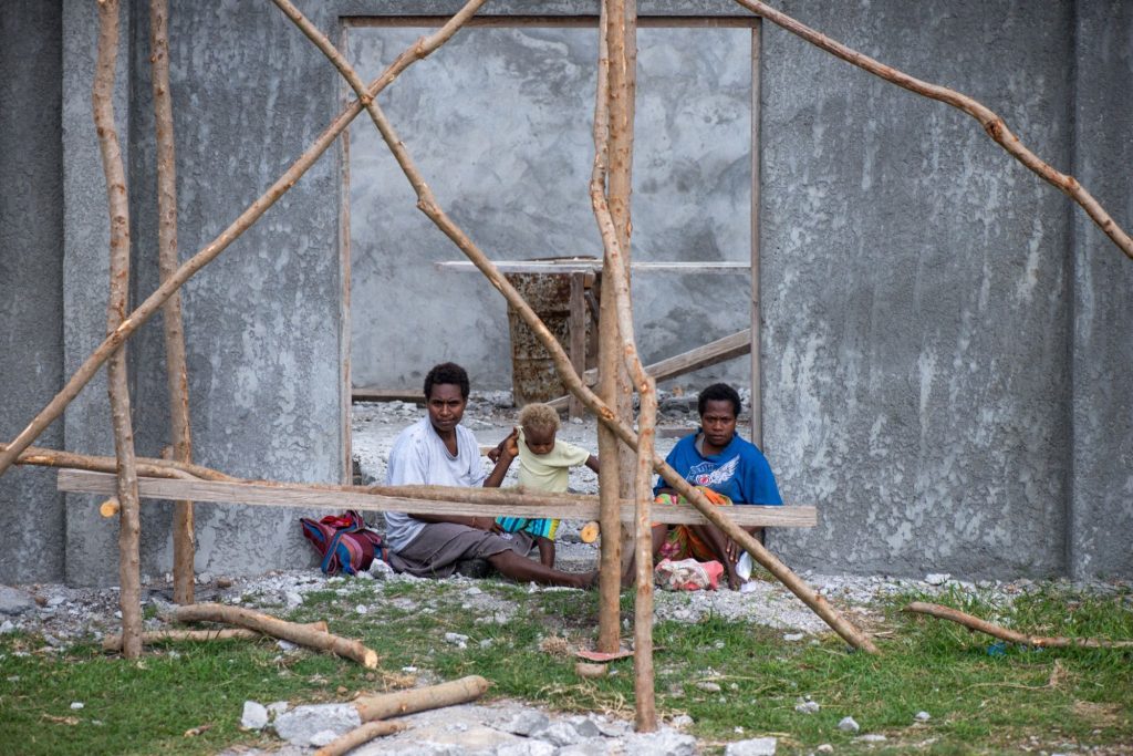 Two women and a child in the entrance to a half-constructed building in Lenakel, Tanna